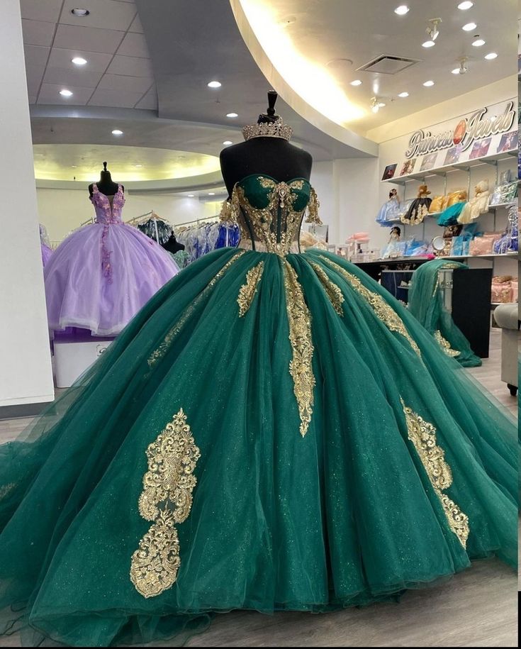 a green and gold ball gown on display in a store