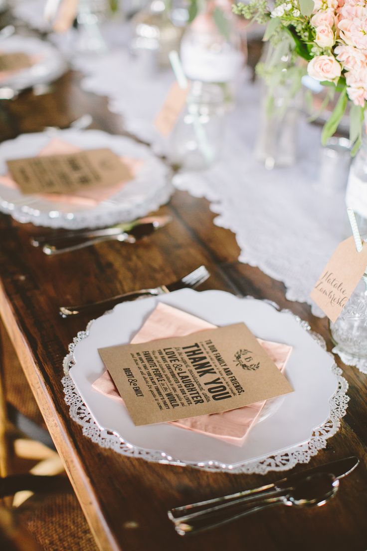 the table is set with pink napkins and place cards