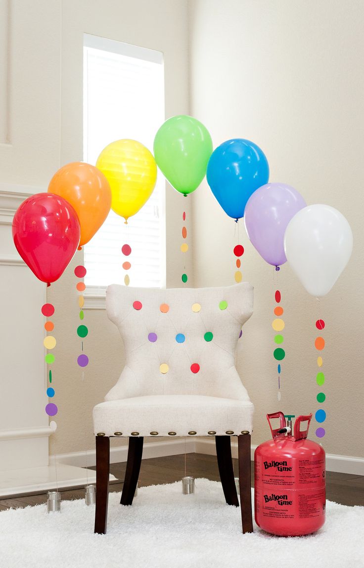 a bunch of balloons that are floating in the air on a table with confetti