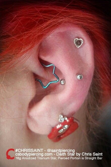 a woman with red hair has two piercings on her ear