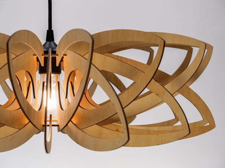 the light fixture is made out of wood and has an intricate design on it's side