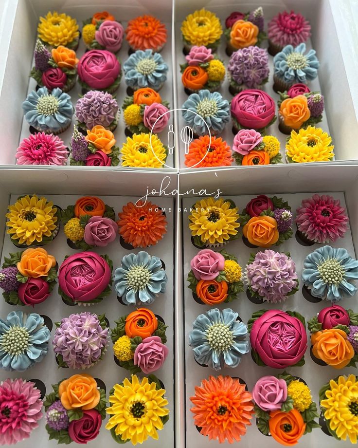 two boxes filled with cupcakes covered in frosting and colorful icing flowers