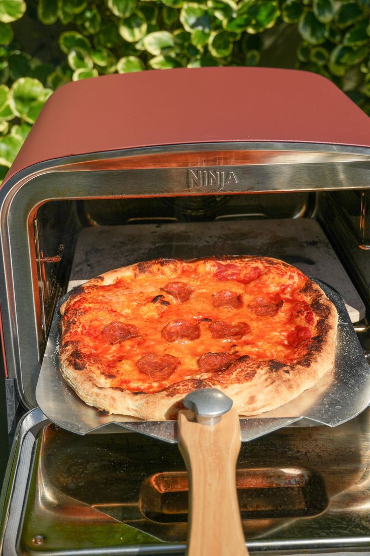 a pizza is being cooked in an oven with a spatula on the handle and it's ready to be put into the oven