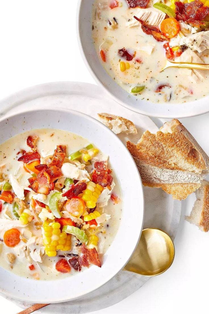 two white bowls filled with soup and bread