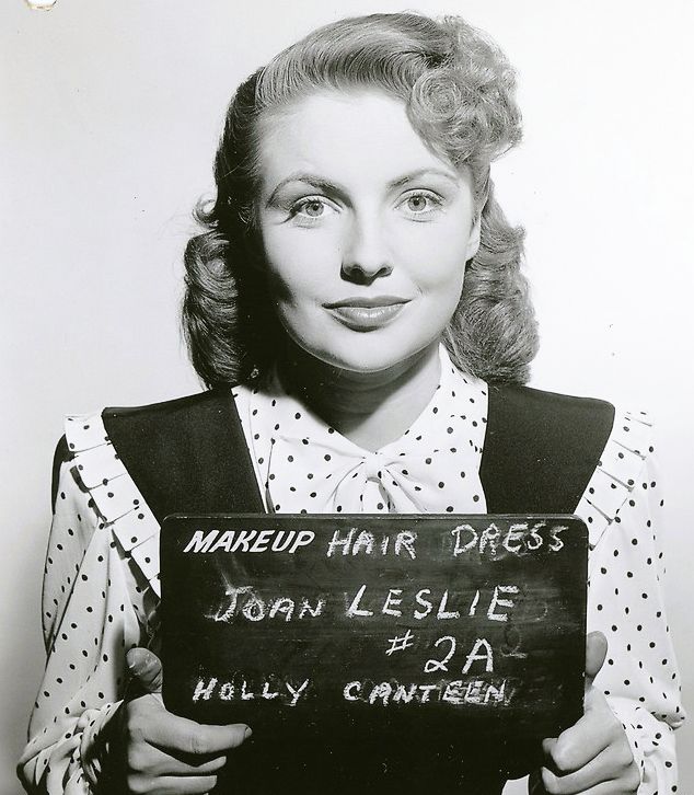 an old black and white photo of a woman holding a sign that says makeup hair dress