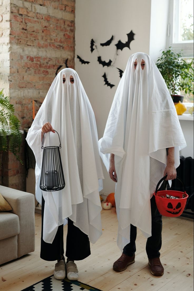 Cute couple posing as creepy happy ghosts for Halloween spooky season wearing white sheets or blankets with holes for eyes Ghost Costume Women, Easy Ghost Costume, Original Costume Ideas, Neighborhood Halloween, Costumes Faciles, Black And White Costume, White Halloween Costumes, Halloween Parejas, Halloween Costumes To Make