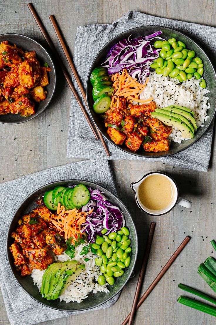 two bowls filled with food next to chopsticks