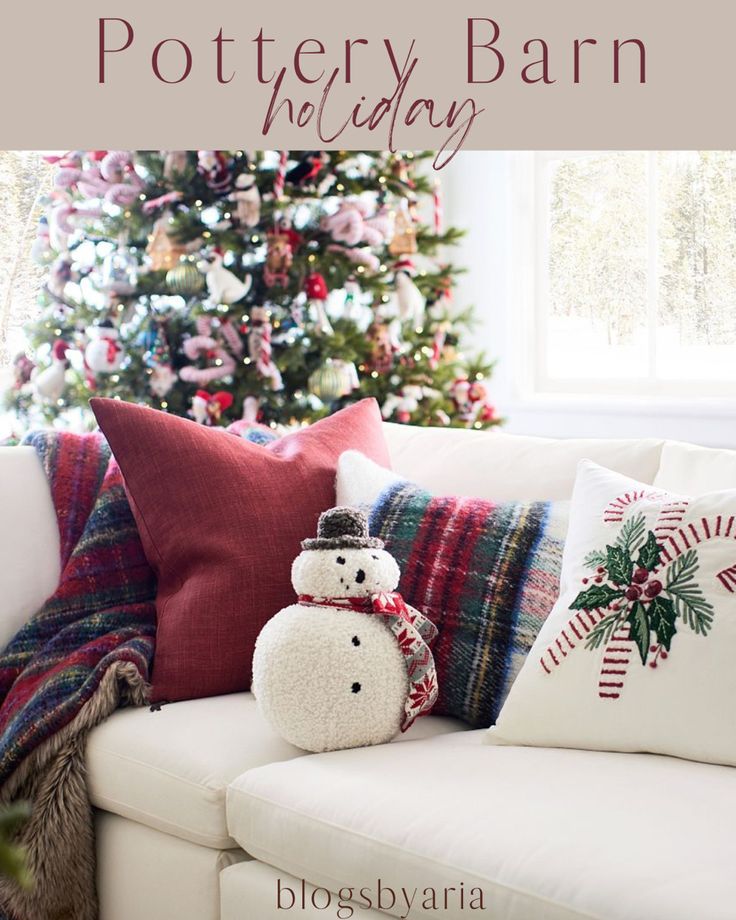 a white couch sitting next to a christmas tree with a snowman pillow on it