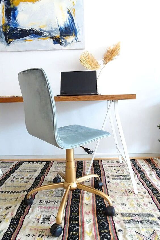 a chair sitting on top of a rug in front of a desk with a laptop