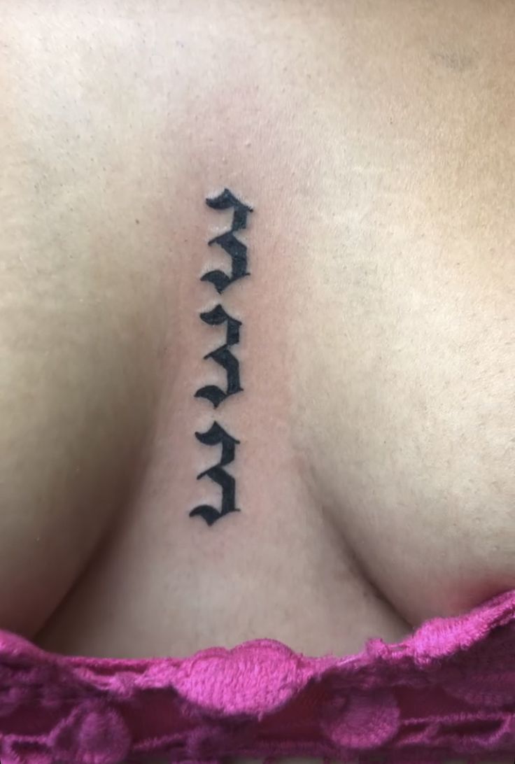 the back of a woman's breast with an arrow tattoo on it