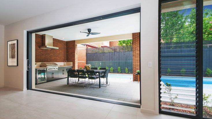 an open living room and dining area with sliding glass doors that lead to the pool