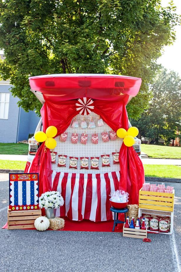 a circus themed birthday party with red and white striped drapes, yellow balloons, and cupcakes