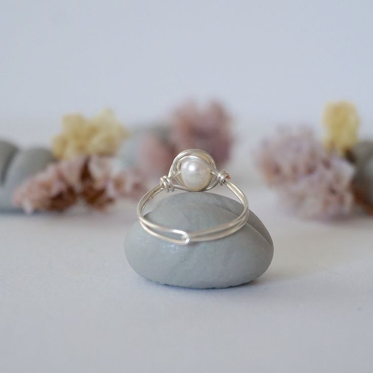 Connect to your inner Goddess with the energies of this uniquely crafted freshwater pearl ring. Our pearl ring is known for: HANDMADE ORIGINAL DESIGN - We customize each pearl ring to the unique shape of its stone. Our ring has an easy to wear, stackable design. Tailor it to fit your mood and style. AUTHENTIC PEARLS & ALLERGY FREE MATERIALS - Your freshwater pearl is authentic and natural. We only use high quality nickel-free, lead-free and allergy-free materials. Ring Specifics: SIZE & MATERIALS - The size of the pearl is 3.5-4 mm. Ring is available in sizes 5 through 11 and in 2 different metal materials: silver plated copper and 925 sterling silver. FEEL THE VIBE OF PEARL - Pearl signifies innocence and faith and is bringing calming effect. Pearl is June's Birthstone and great for Gemin Cheap Wedding Pearl Ring With Metal Band, Adjustable Minimalist Sterling Silver Pearl Ring, Pearl White Sterling Silver Ring For Gift, Sterling Silver Pearl Drop Ring For Promise, Adjustable Pearl Drop Round Rings, Sterling Silver Pearl Drop Ring For Promise Occasions, Adjustable Pearl Drop Ring, Elegant Sterling Silver Pearl Drop Ring, Silver Rings With Pearl Charm