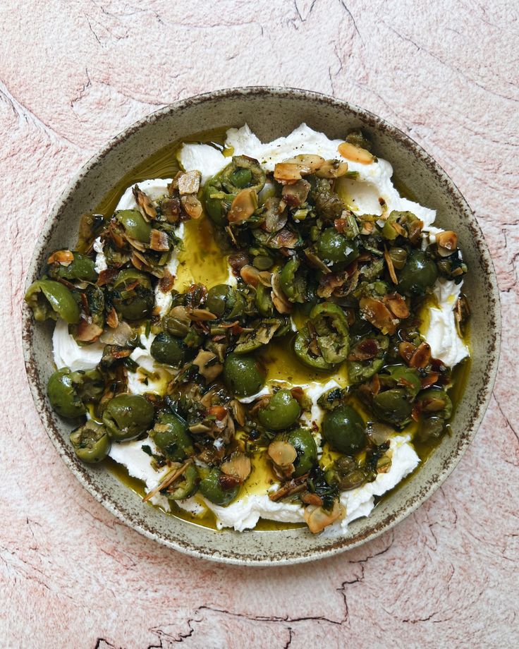 a bowl filled with green olives and whipped cream