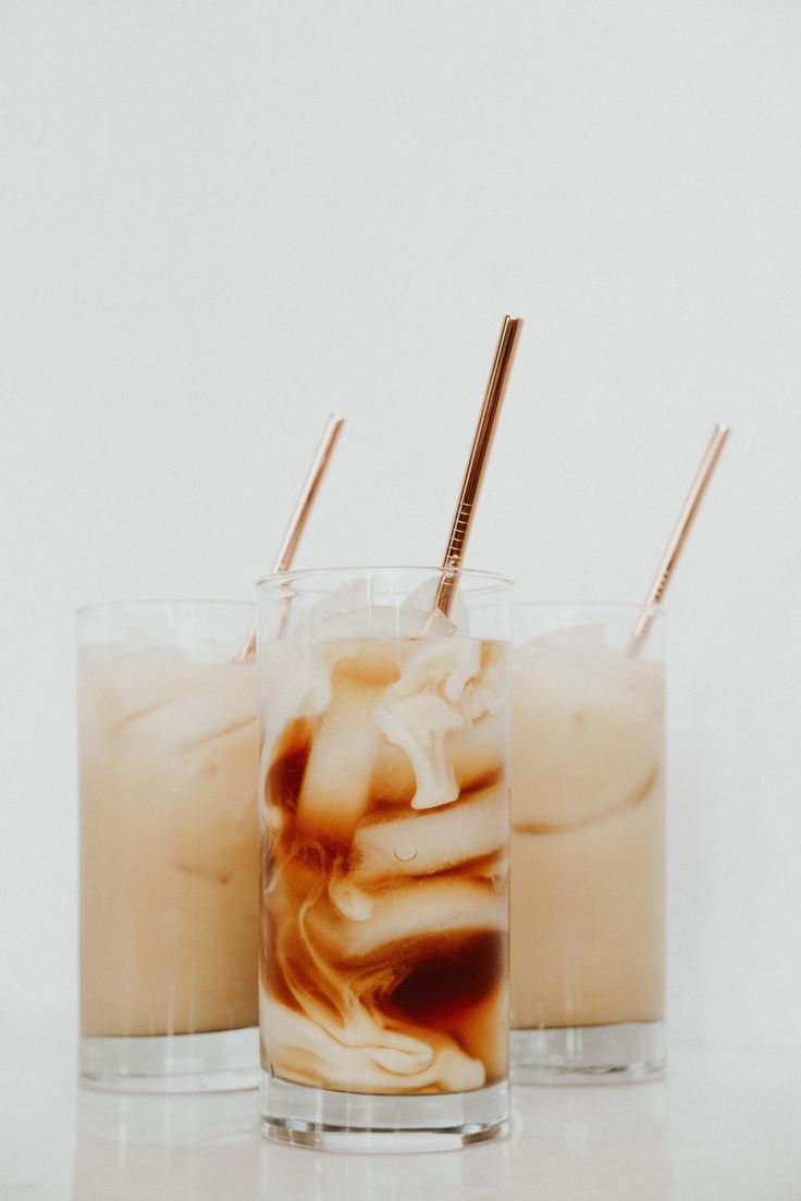 two glasses filled with liquid and ice cream