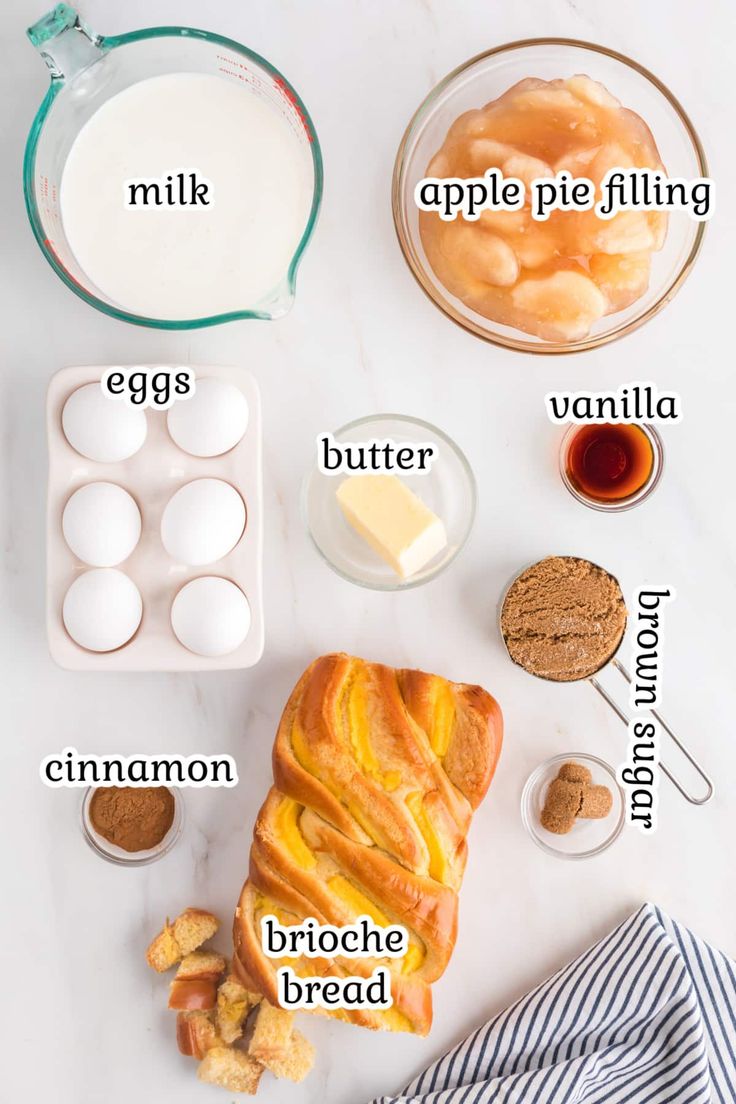 the ingredients for an apple pie laid out on a white counter top, including eggs, butter, cinnamon, and almonds