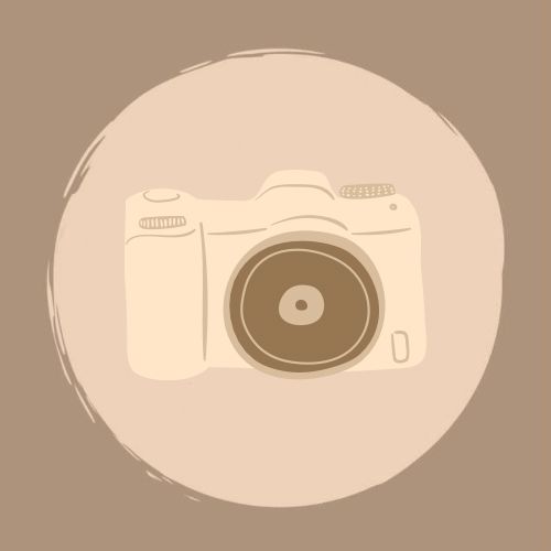 a camera sitting on top of a white plate next to a brown and beige background