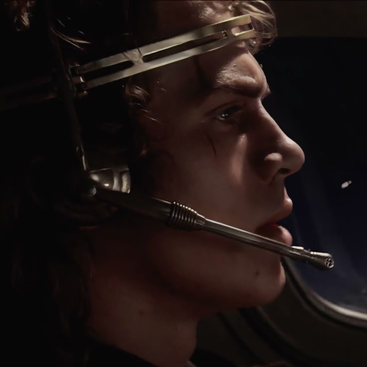 a man with a sci - fi helmet on his head looking out an airplane window