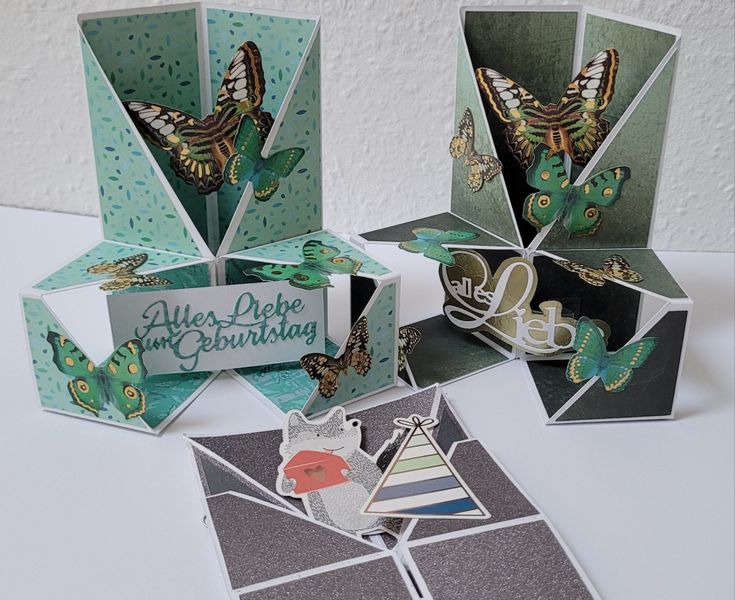 some cards are sitting on a table and one has a card in the shape of a butterfly