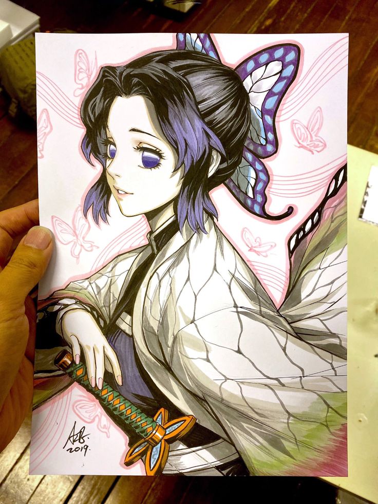 a person holding up a drawing of a woman with blue hair and butterfly wings on her head