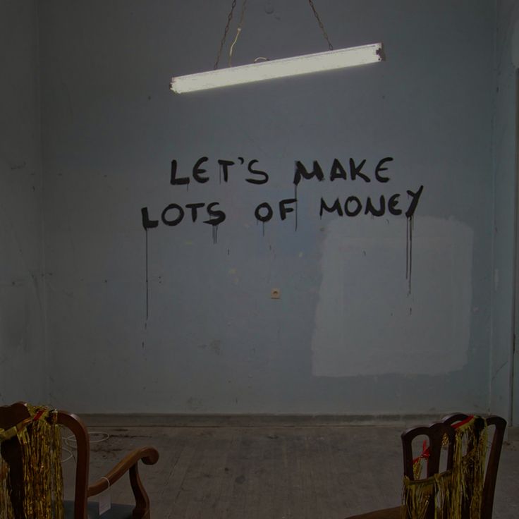 two chairs sitting in front of a white wall with writing on the walls and underneath them