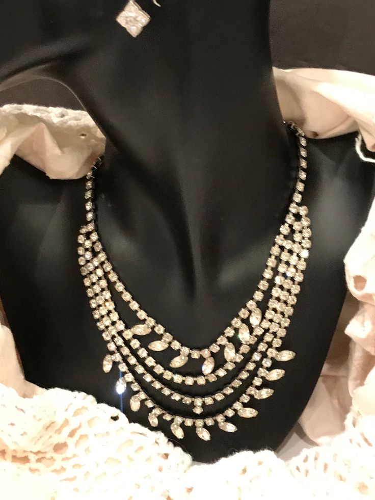 "This is a stunning, vintage, rhinestone, bib necklace. The necklace is in excellent, vintage condition, and is unique and versatile. These necklaces are becoming more and more difficult to find in this condition. Each rhinestone is set, not glued. This one is not missing any stones, and all stones are clear. The necklace is 17\" long, and weighs 52g. The necklace is not signed, but beautifully made." Elegant Necklaces With Sparkling Stones For Vintage Events, Vintage Diamond Necklace With 17 Jewels For Evening, Vintage Sparkling Stones Necklaces For Party, Jeweled Costume Jewelry Necklaces For Evening, Vintage Necklaces With Sparkling Stones For Evening, Vintage Crystal Rhinestone Necklace For Party, Vintage Evening Necklaces With Sparkling Stones, Vintage Crystal Necklace With Sparkling Stones, Vintage Rhinestone Party Necklace