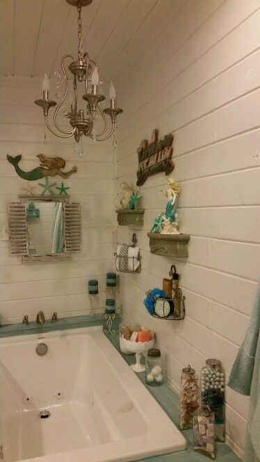 a bath tub sitting under a chandelier in a bathroom