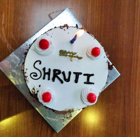 a cake with the word shrut on it sitting on top of a wooden table