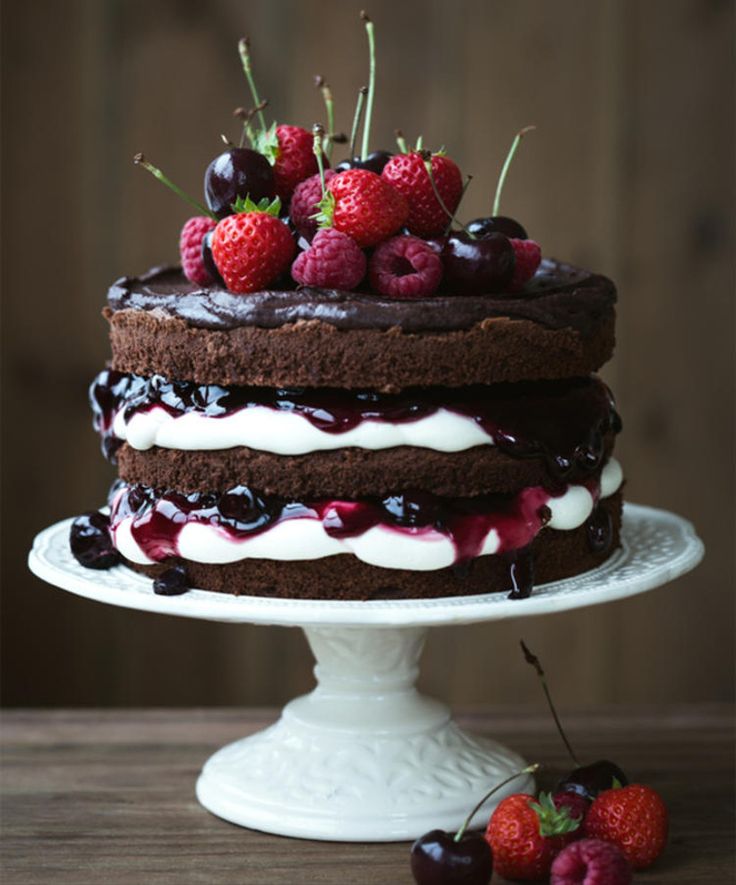 a chocolate cake with cherries and whipped cream