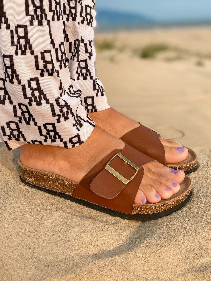 Adorn your feet with effortless style when you don this buckle slide that is ideal for your warm weather attire. Slip-on / buckle closure Man-made upper Cushioned footbed cushioned EVA sole Comfortable Slides With Buckle Closure And Round Toe, Adjustable Buckle Closure Footbed Sandals, Comfortable Closed Toe Footbed Sandals With Buckle, Casual Slip-on Slides With Tang Buckle, Casual Tang Buckle Slip-on Slides, Adjustable Flat Slides With Buckle Closure, Flat Heel Footbed Sandals With Buckle Closure For Vacation, Flat Heel Footbed Sandals With Buckle Closure For Beach, Comfortable Adjustable Footbed Sandals With Buckle