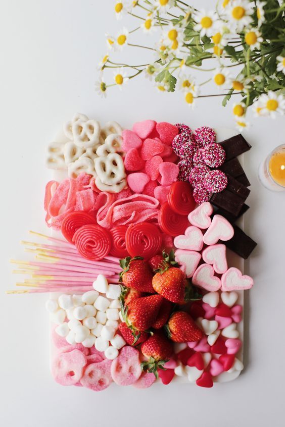 valentine's day treats laid out on a white surface with flowers and an egg