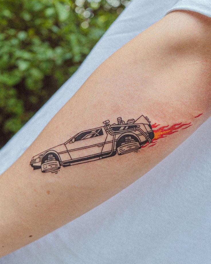 a man's arm with a car drawn on it and flames coming out of the back