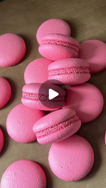 pink macaroons are arranged on a table