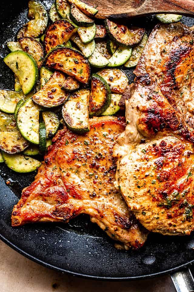 a skillet with chicken, zucchini and sliced cucumbers on it