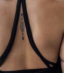 the back of a woman's bra with an arrow tattoo