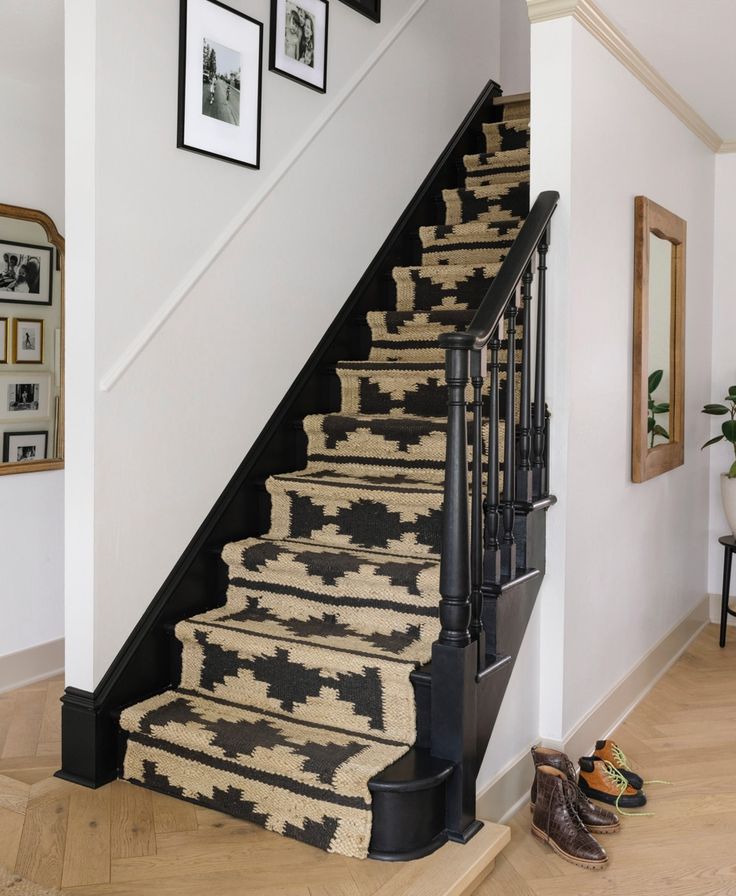 there is a stair case with carpet on the bottom, and two framed pictures on the wall