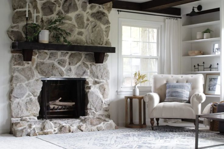 a living room filled with furniture and a fire place next to a stone wall covered in shelves