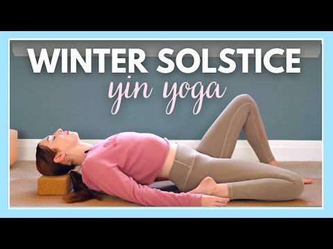 a woman is laying on the floor with her legs crossed and head down, in front of a blue wall that says winter solstice yin yoga