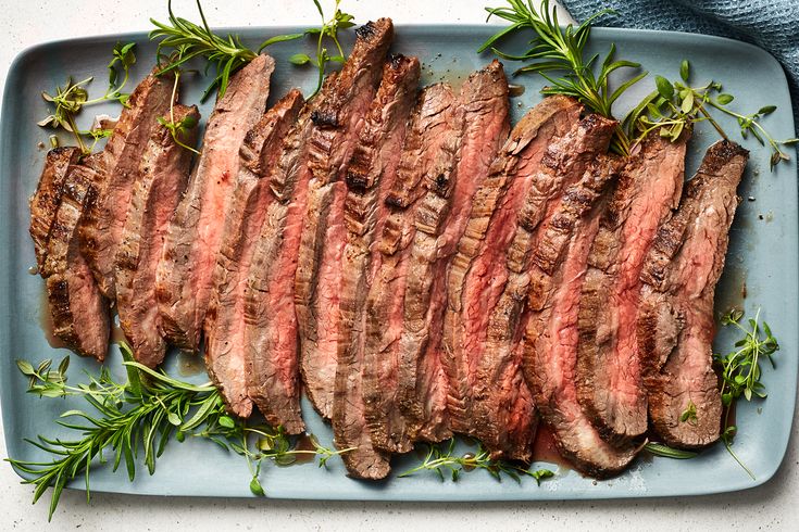 sliced steak with herbs on a blue plate