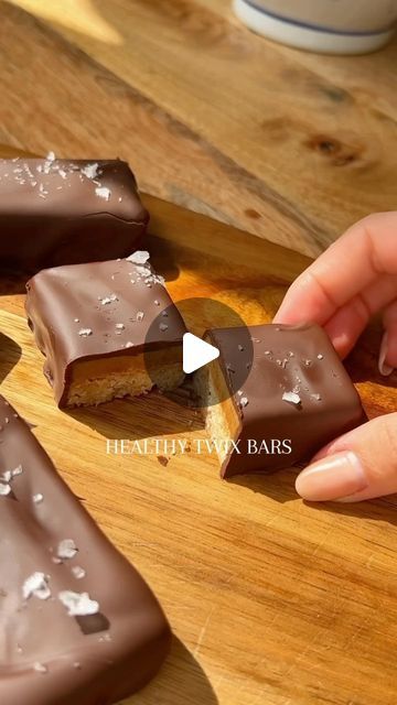 someone is cutting up some chocolate bars on a wooden board