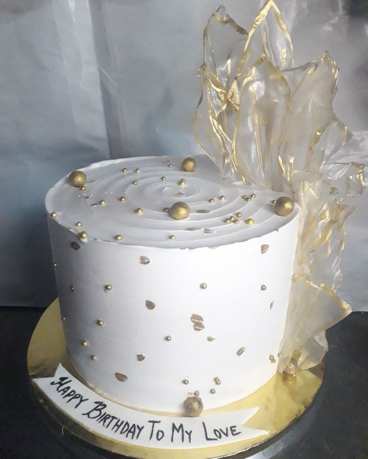 a white and gold birthday cake on a silver platter with the words happy birthday to my love written on it