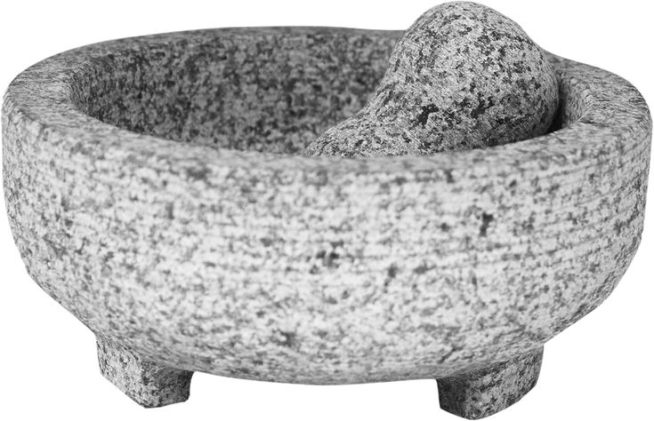 a stone mortar bowl with two small rocks in the center and one large rock on top