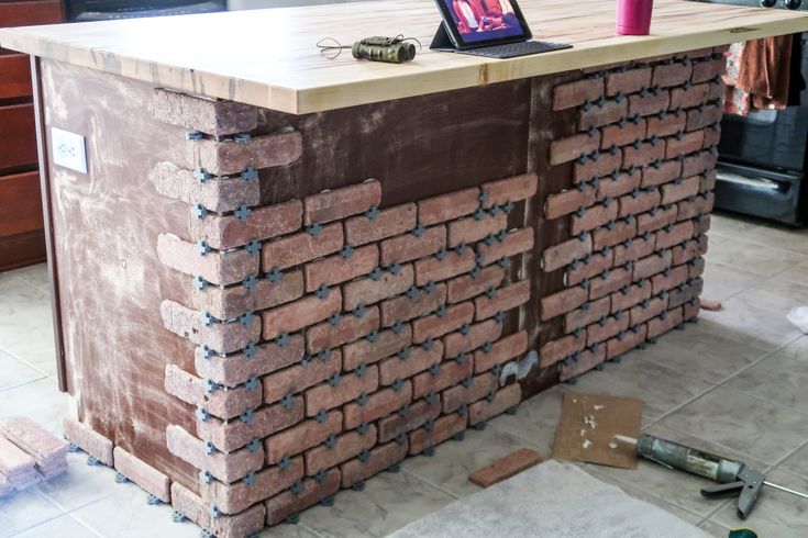 a laptop computer sitting on top of a brick counter