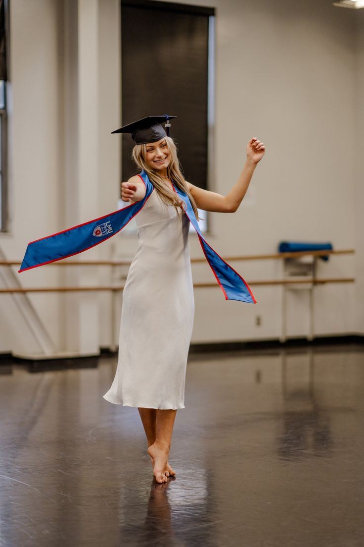 a woman in a graduation gown is dancing