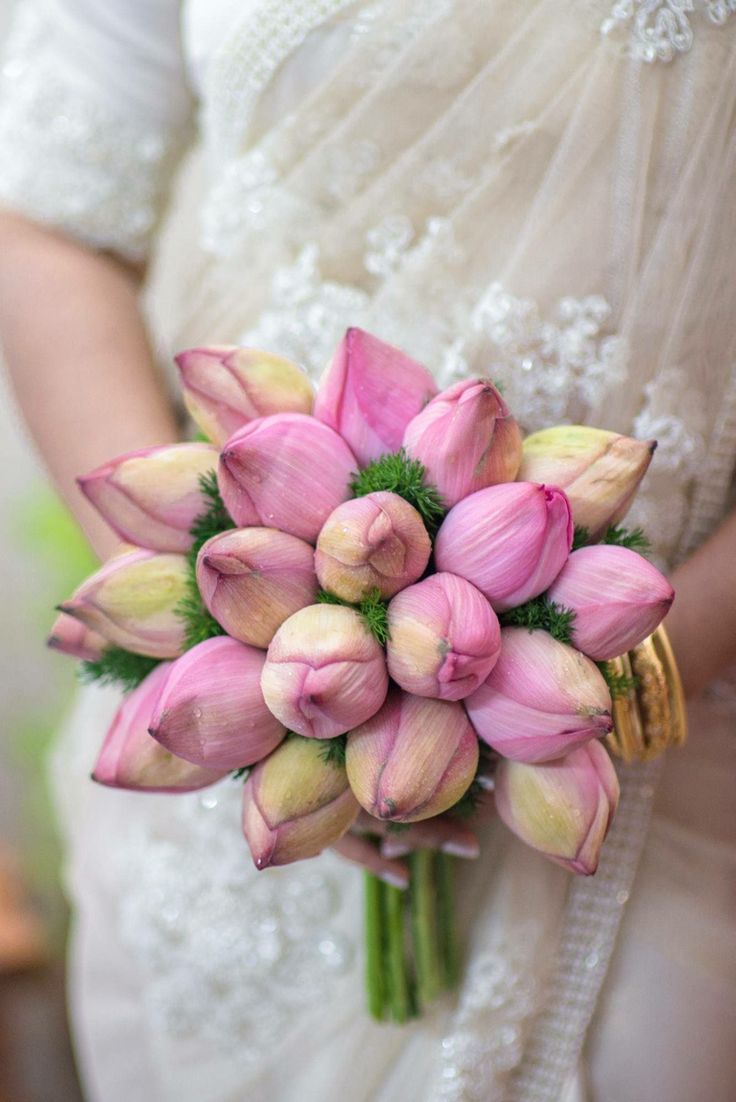 a bride holding a bouquet of pink tulips