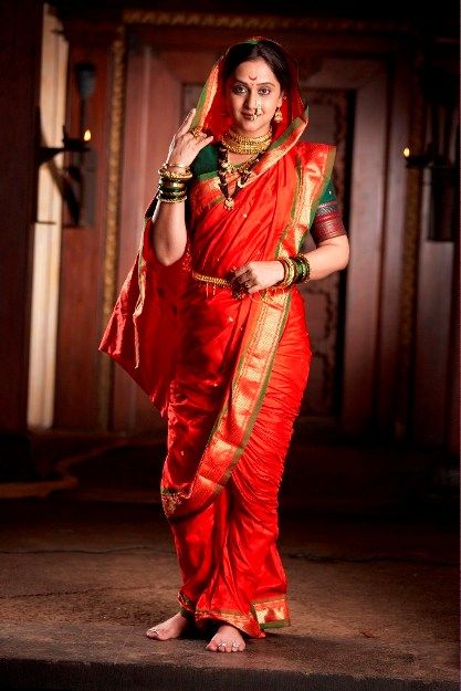 a woman in a red sari posing for the camera