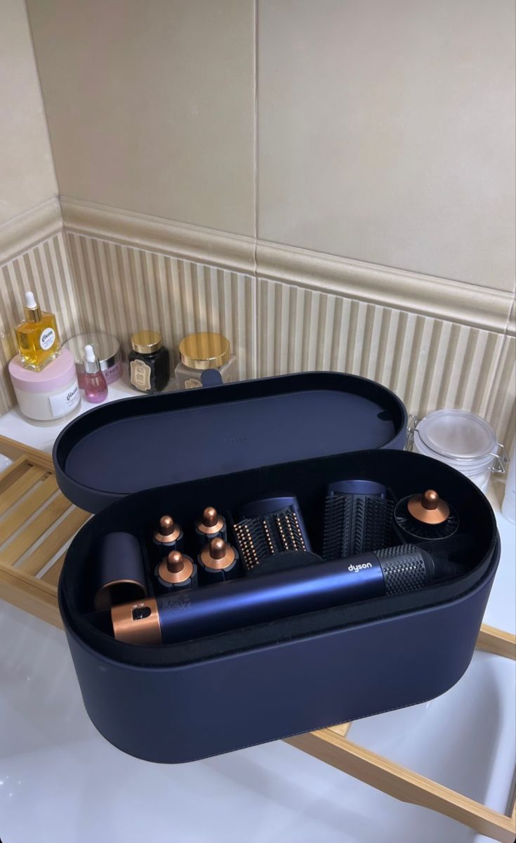 a black tray with some hair products in it on a white counter next to a sink