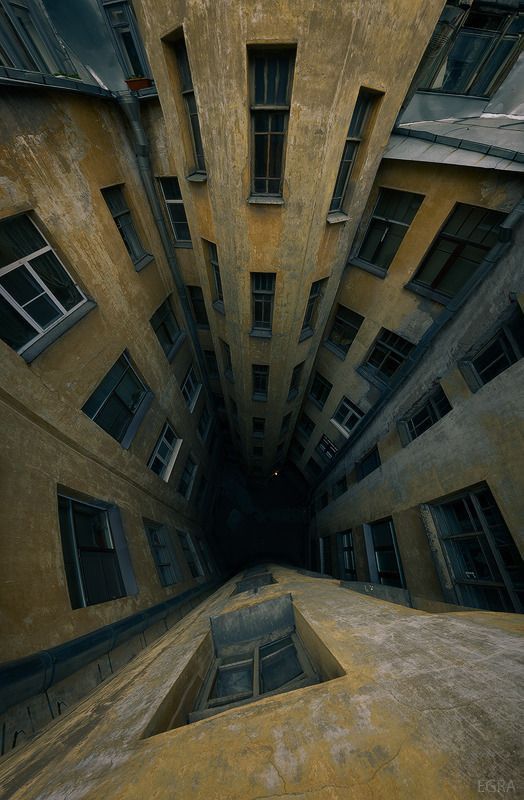 looking up at an old building with multiple windows and balconies on the second floor