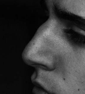 black and white photograph of a man's face with his eyes closed, close up