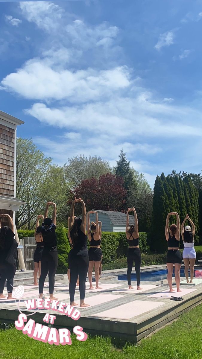 a group of young women standing on top of a cement platform in front of a house